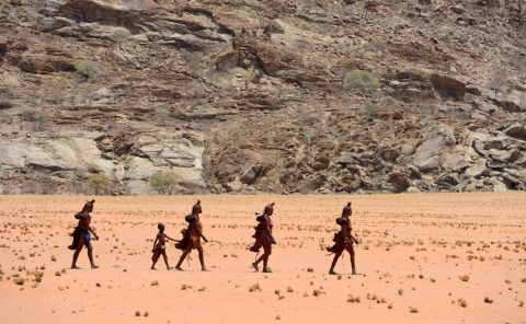 Femmes Himbas marchant dans le désert, vallée du Marienfluss, désert du Kaokoland, Namibie, Afrique