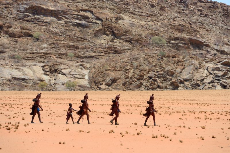 Femmes Himbas marchant dans le désert, vallée du Marienfluss, désert du Kaokoland, Namibie, Afrique