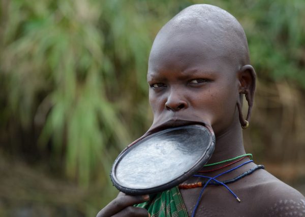 Jeune femme Suri arborant un labret d’environ 15 cm de diamètre, signe de richesse, vallée de l'Omo, Éthiopie, Afrique